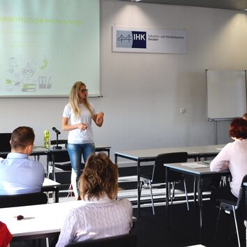 Referentin vor Gruppe während eines Seminars